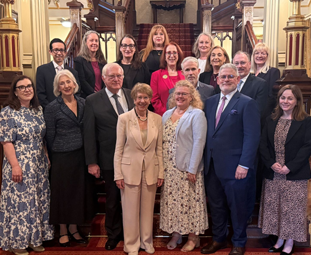 Group photo of people in front of entry way stairs